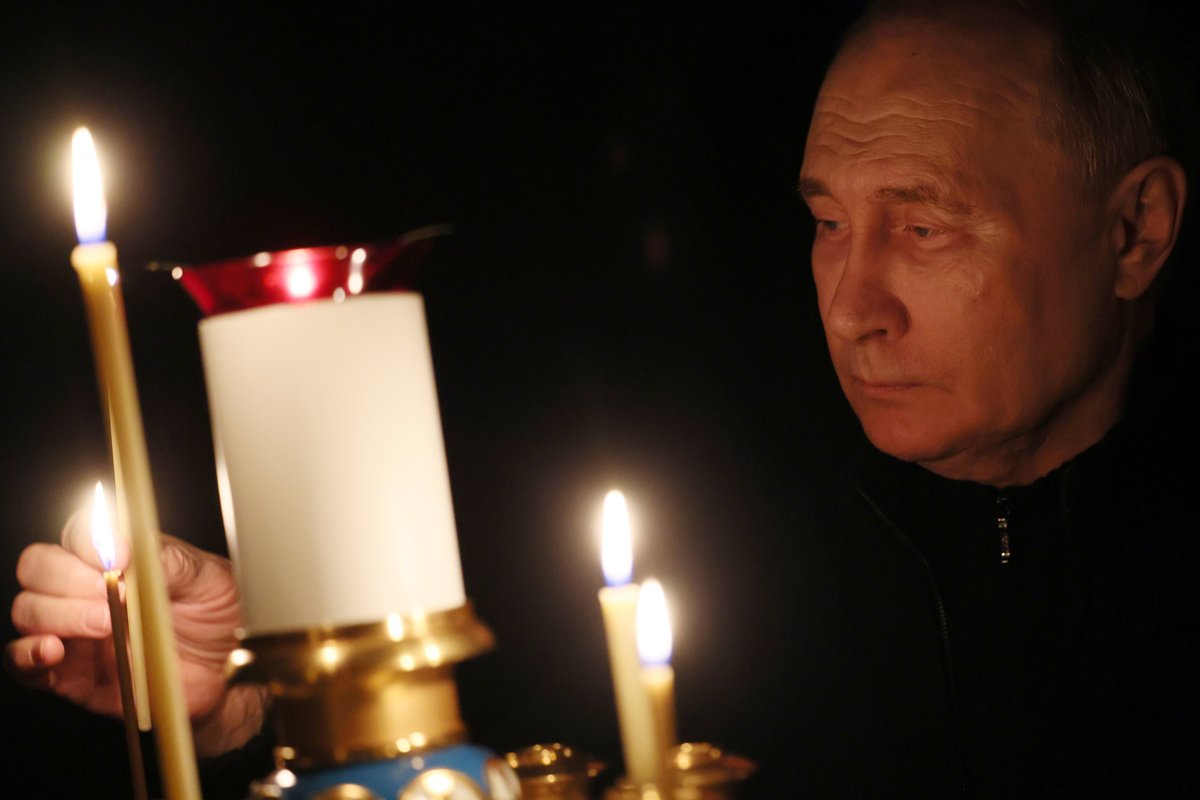 Владимир Путин зажигает свечу в память о жертвах теракта в  Crocus City Hall , 24 марта 2024 года. Фото: Михаил Мецель / Спутник / Kremlin / EPA